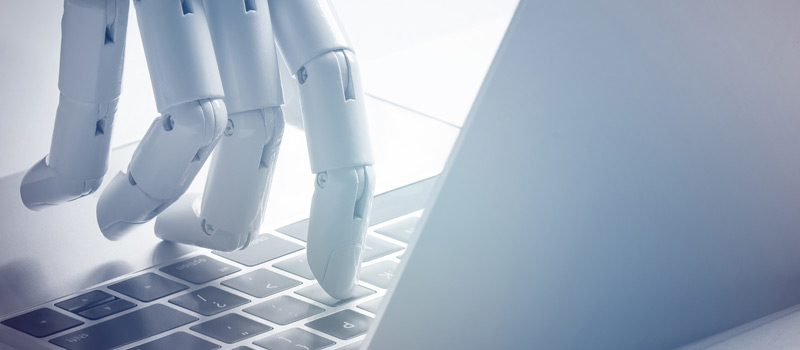 Representación futurista de la mano de un robot tecleando en un ordenador.