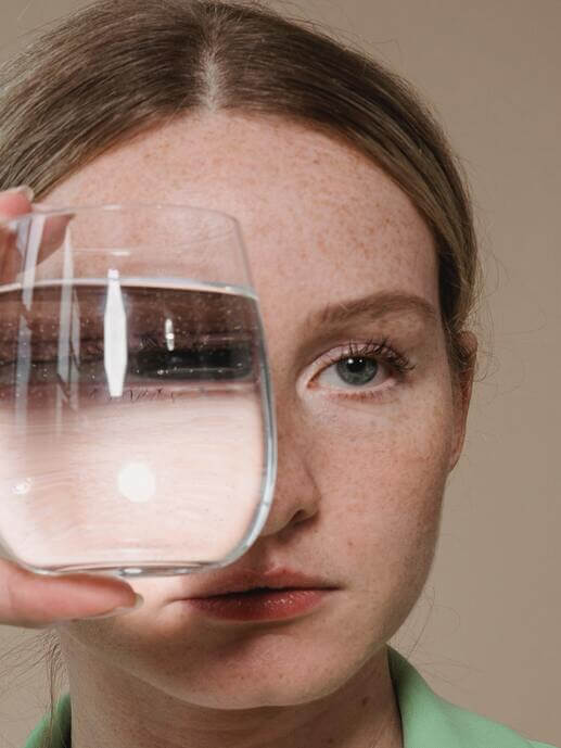 Chica con vaso de cristal con agua 