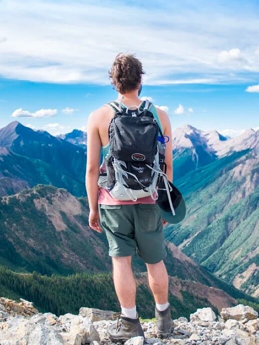 Persons. Young man on a back to back and looking at the landscape