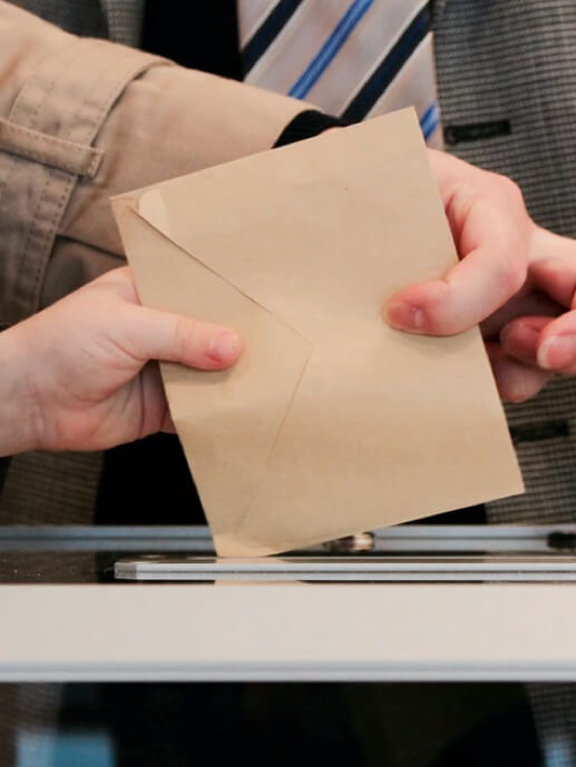 Administração Electrónica Babel INE. Uma pessoa a colocar o seu voto numa urna de voto.