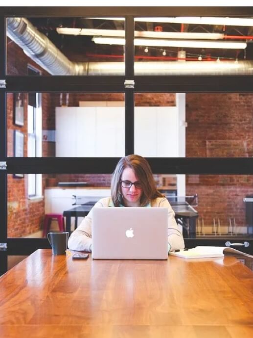 Babel Digital Workplace. Mujer trabajando en una sala con un portátil